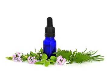 Medicinal herbs for hayfever and sneezing allergies with blue bottle on white. Natural antihistamine treatment with nettle, oregano, marjoram, rosemary, thyme, sage.