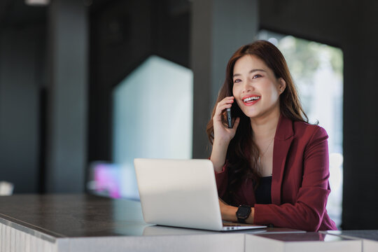 Asian businesswoman smiling while talking on mobile phone