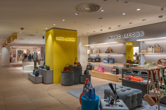Germany Berlin November 21, 2025. Marc Jacobs shop corner in a high-end department store with handbags on display. Bright modern interior design with yellow accent wall and luxury accessories.