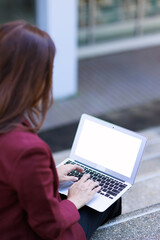 Naklejka premium Woman working on laptop outdoors creating content