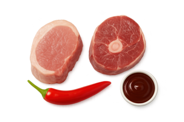 Two raw pork chops with red chili pepper and small cup of brown dipping sauce on transparent background