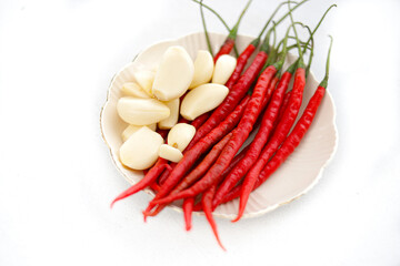 Fresh Red Chili Peppers and Garlic Cloves on White Plate – Spicy Asian Cooking Ingredients, Aromatic Seasoning for Indonesian, Thai, and Southeast Asian Cuisine