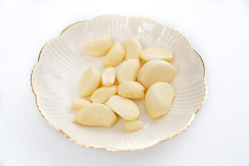 Fresh Peeled Garlic Cloves on Elegant White Plate – Aromatic Cooking Ingredients for Asian, Indonesian, and Gourmet Culinary Dishes