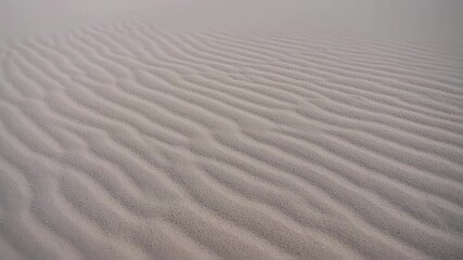 Close-up of wind-swept sand dunes with rippled patterns in a desert landscape. - Powered by Adobe