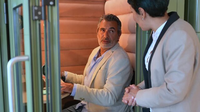 Mature businessman ending conversation in a phone booth