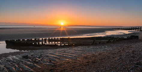 Obraz premium Shipwreck on Broomhill Sands low tide sunset on the east Sussex coast south east England UK