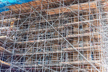Scaffolding surrounds a seven‑story building in England, providing essential safety for construction workers and protecting the public below