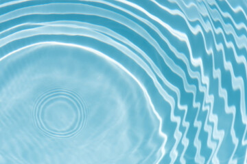 Blue water with ripples on the surface. Defocus blurred transparent blue colored clear calm water surface texture with splashes and bubbles. Water waves with shining pattern texture background.