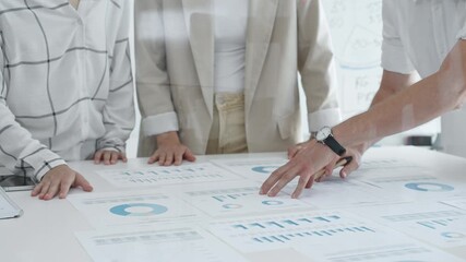 Business team analyzing financial charts and graphs, pointing at statistics and discussing data, working together on business project in modern office, close up. Business people concept - Powered by Adobe