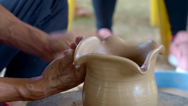 Close-up of artisan hands shaping a decorative wavy rim on a wet clay pot during a pottery workshop demonstrating traditional ceramic craftsmanship skills - Powered by Adobe