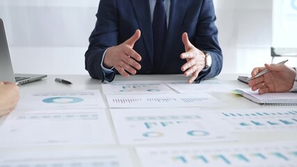 Business professionals discussing financial reports and marketing charts during corporate meeting, focusing on strategy, planning, data analysis, and teamwork - Powered by Adobe