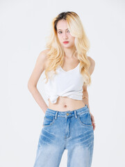Fototapeta premium Asian confident beautiful attractive young woman blonde long hair stand wear sleeveless top jeans on white background studio, portrait lifestyle fashion street outfit trendy style pose look at camera.