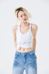 Asian confident beautiful young woman blonde hair high tied  standing wearing sleeveless top jeans...