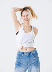 Asian confident beautiful young woman blonde hair high tied  standing wearing sleeveless top jeans...