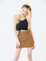Asian beautiful attractive young woman blonde long hair stand wear black sleeveless top brown short skirt on white background studio, portrait fashion street outfit trendy style pose look at camera.