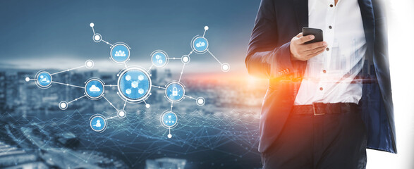 A business professional stands in an urban environment holding a smartphone, surrounded by digital network elements illustrating modern connectivity and technology trends. Tessel