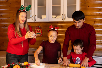 A family is enjoying time together baking in the kitchen for Christmas