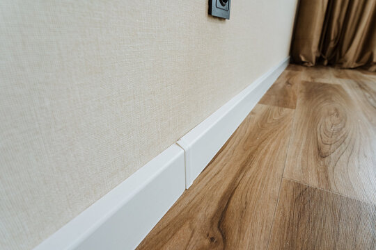 contemporary design showcasing minimal edges and coordinated color scheme, stylish white baseboard paired with natural light illuminating modern wooden flooring setup for lifestyle imagery