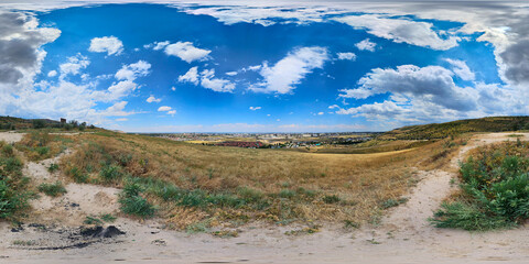 360 panorama of serene landscape with dry grass and distant city skyline, equirectangular projection © lucky pics