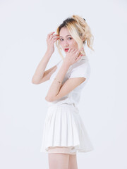 Asian confident attractive beautiful young woman blonde hair tied stand wearing white shirt top mini skirt sport background studio, portrait lifestyle fashion outfit trendy style pose look at camera.