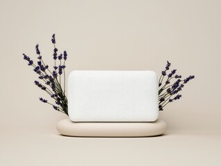A white rectangular object, possibly a pillow or soap, is displayed on a beige stand with lavender sprigs on either side.