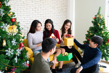 Asian young people are gathering for Christmas and New Year party, smiling at each other, and celebrating the festival