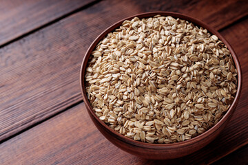 Raw Rolled Oats in Bowl on Dark Wooden Table Copy Space