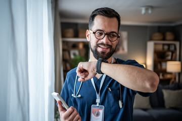 Doctor man checking smartwatch during home visit consultation