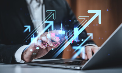 Businessman analyzing financial data with futuristic graphs and arrows representing growth concept on digital interface over laptop background.