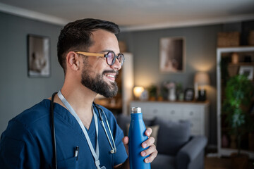 Male doctor taking a break and hydrating at home