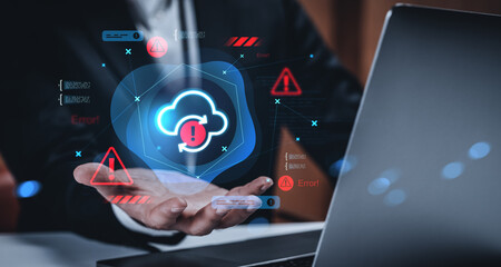 Cloud error warning concept with digital interface and businessman holding virtual alert icon in hand above laptop on dark office background.