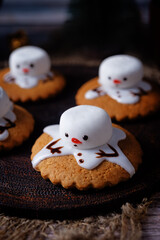 Gingerbread cookie with melting snowman topping on a wood background