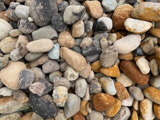 Pile of smooth, colorful river rocks. The image captures the texture and variety of natural stones