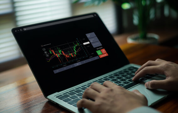A user analyzing a digital trading chart on a laptop, featuring candlestick patterns, market indicators, and financial data, representing online investment, forex analysis, and modern financial.