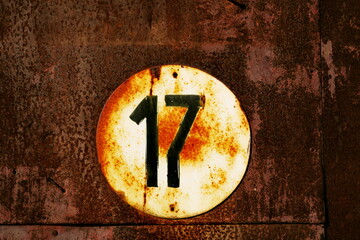 Numéro 17. Plaque de numéro de rue. Fond de métal rouillé.