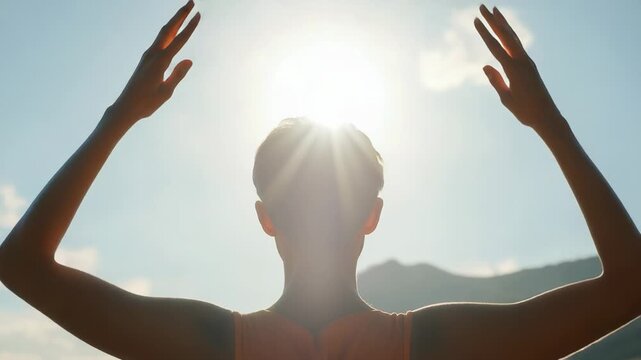 Video A person stands looking up at the sun with their hands on their head, capturing a moment of awe and wonder