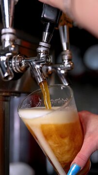 Pouring beer from tap into a glass, close-up, refreshing drink concept