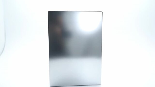 Silver Rectangular Box on White - A tall, rectangular silver box stands upright against a stark white background.