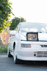 old white car with retractable headlights
