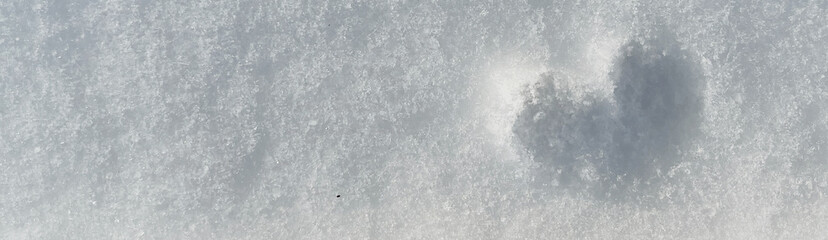 Soft white snow covers the ground, with a subtle heart shape imprint visible, creating a serene winter scene that evokes feelings of love and tranquility
