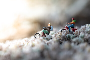 Miniature people riding motorbikes on a blurred background representing travel and adventure