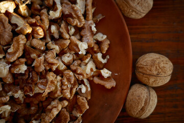 Chopped walnuts and whole nuts on a wooden surface in a rustic kitchen setting