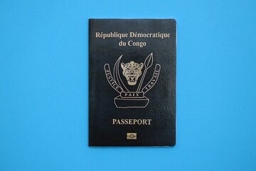 Democratic Republic of Congo black passport on light blue table background close up. Concept of...