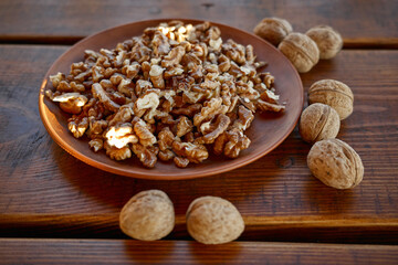 Walnuts and shells arranged on a wooden table with natural light in a cozy setting
