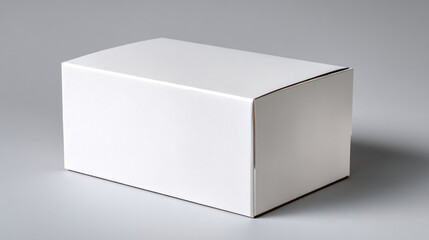 A simple white cardboard box sitting on a gray surface in a studio setting