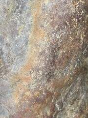 Close-up shot of a rough, textured stone surface. The image showcases the natural grain and imperfections of the rock