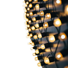 Diagonal String of Warm Yellow Incandescent Christmas Lights With Shadows on a Textured Wall With Black Background