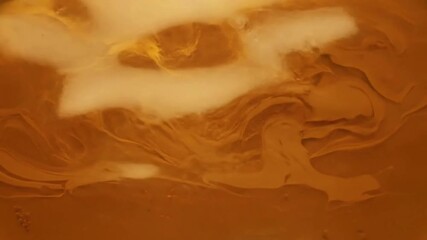 Hypnotic visual journey through a rich, viscous golden medium, highlighting its subtle movements, depth, and captivating natural luminescence with seamless transition. - Powered by Adobe