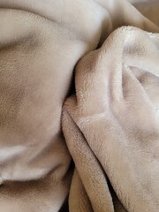 Closeup of beige fleece blanket  © MarieCéline