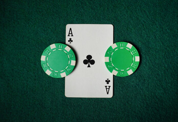 Two green poker chips flank an Ace of clubs on a green felt surface. The scene captures the excitement of a poker game, highlighting the strategy and chance involved